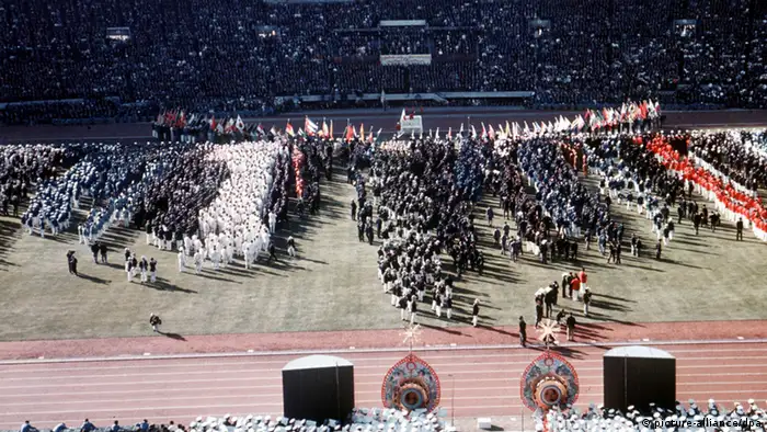 Der Einmarsch der Nationen ins Nationalstadion von Tokio bei der feierlichen Eröffnung der XVIII. Olympischen Sommerspiele am 10.10.1964 nähert sich seinem Abschluss, der Innenraum der mit Zuschauern dicht besetzten Sportstätte hat sich mit den Mannschaften der teilnehmenden Länder gefüllt. (Foto: dpa)