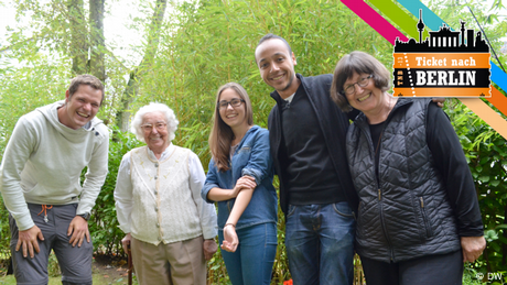 Drei Teilnehmer von Ticket nach Berlin lachen gemeinsam mit zwei älteren Damen in die Kamera.