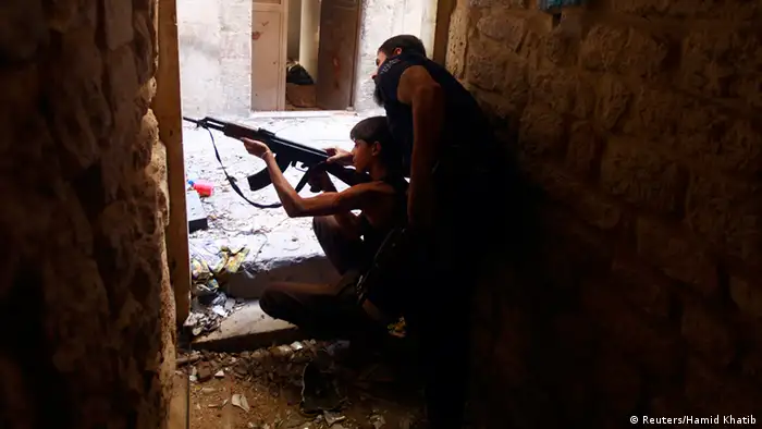 Ahmad Abu Layl, a 15 year-old fighter from the Free Syrian Army, aims his weapon as his father stands behind him in Aleppo September 10, 2013. REUTERS/Hamid Khatib (SYRIA - Tags: POLITICS CIVIL UNREST CONFLICT MILITARY)