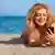 Туристка з мобільним телефоном на пляжі - символічне фото