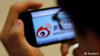 A man holds an iPhone as he visits Sina's Weibo microblogging site in Shanghai in this May 29, 2012 file photo. Sina Corp, one of China's biggest Internet firms, runs the microblogging site, which has 500 million registered users. It also employs the censors. The Sina Weibo censors are a small part of the tens of thousands of censors employed in China to control content in traditional media and on the Internet. Picture taken May 29, 2012. REUTERS/Carlos Barria/Files (CHINA - Tags: POLITICS SCIENCE TECHNOLOGY BUSINESS TELECOMS)