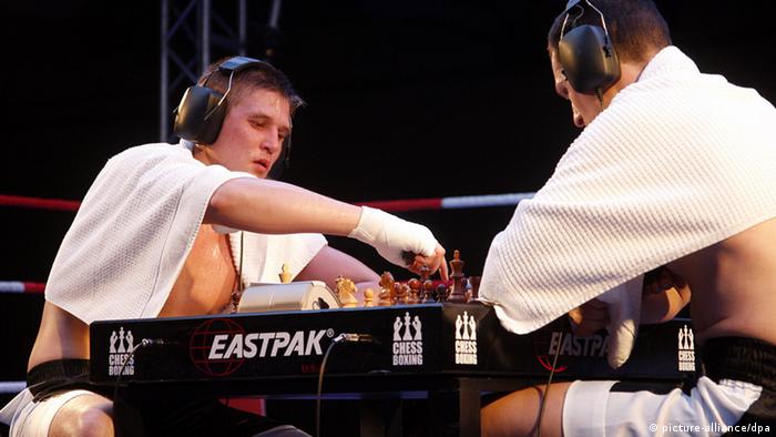 Two competitors in chess boxing at the chess board