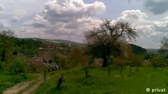 grüne Hügel mit einem, im Tal gelegen, Dorf