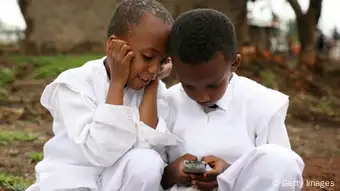 Children look at a screen of mobile phone