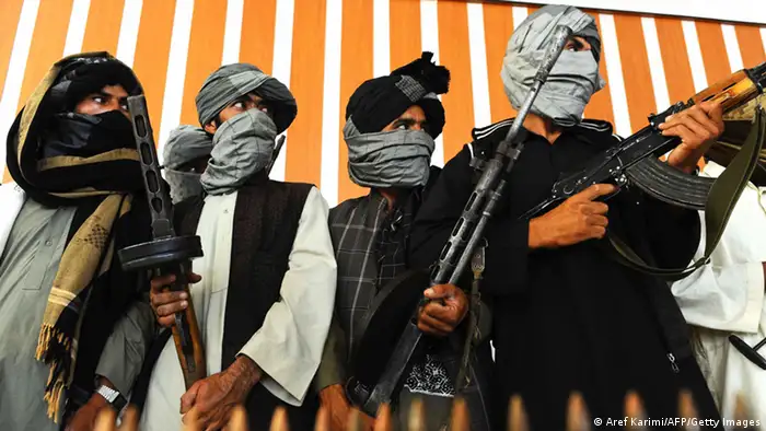 Former Taliban fighters stand with their weapons during a ceremony after joining Afghan government forces in Herat on August 7, 2013. About 100,000 foreign combat troops, 68,000 of them from the US, are due to exit by the end of 2014, and NATO formally transferred responsibility for nationwide security to Afghan forces a week ago. AFP PHOTO/ Aref Karimi (Photo credit should read Aref Karimi/AFP/Getty Images)