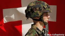 BERN, SWITZERLAND - SEPTEMBER 08: A Swiss soldier stands at attention in front of a Swiss flag before the arrival of German President Christian Wulff on September 8, 2010 in Bern, Switzerland. Switzerland has long prided itself on its political neutrality. (Photo by Sean Gallup/Getty Images)
