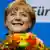 German Chancellor and leader of the Christian Democratic Union (CDU) Angela Merkel smiles as she holds flowers after first exit polls in the German general election (Bundestagswahl) at the party headquarters in Berlin September 22, 2013. REUTERS/Kai Pfaffenbach (GERMANY - Tags: POLITICS ELECTIONS)