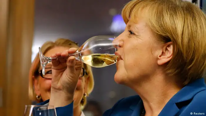 German Chancellor and leader of the Christian Democratic Union (CDU) Angela Merkel drinks a glass of wine as she celebrates after first exit polls in the German general election (Bundestagswahl) at the CDU party headquarters in Berlin September 22, 2013. Merkel won a landslide personal victory in a German election on Sunday, putting her within reach of the first absolute majority in parliament in half a century, a ringing endorsement of her steady leadership in the euro crisis. REUTERS/Fabrizio Bensch (GERMANY - Tags: POLITICS ELECTIONS)