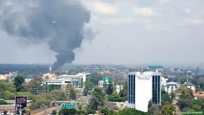 A helicopte and birds fly above as a plume of black smoke billows rising over the Westgate Mall, following large explosions and heavy gunfire, in Nairobi, Kenya Monday, Sept. 23, 2013. Four large blasts rocked Kenya's Westgate Mall on Monday, sending large plumes of smoke over an upscale suburb as Kenyan military forces sought to rescue an unknown number of hostages held by al-Qaida-linked militants. (AP Photo/Riccardo Gangale) ***FREI FÜR SOCIAL MEDIA***