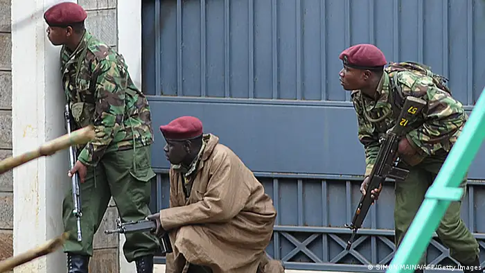 Armed Kenyan policemen take cover outside the Westgate mall in Nairobi on September 23, 2013. Kenyan troops were locked in a fierce firefight with Somali militants inside an upmarket Nairobi shopping mall on September 22 in a final push to end a siege that has left at least 69 dead and 200 wounded with an unknown number of hostages still being held. Somalia's Al Qaeda-inspired Shebab rebels said the carnage at the part Israeli-owned complex mall was in retaliation for Kenya's military intervention in Somalia, where African Union troops are battling the Islamists. AFP PHOTO / SIMON MAINA (Photo credit should read SIMON MAINA/AFP/Getty Images)