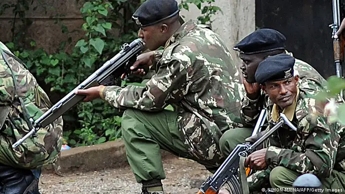 Armed Kenyan policemen take cover outside the Westgate mall in Nairobi on September 23, 2013. Kenyan troops were locked in a fierce firefight with Somali militants inside an upmarket Nairobi shopping mall on September 22 in a final push to end a siege that has left at least 69 dead and 200 wounded with an unknown number of hostages still being held. Somalia's Al Qaeda-inspired Shebab rebels said the carnage at the part Israeli-owned complex mall was in retaliation for Kenya's military intervention in Somalia, where African Union troops are battling the Islamists. AFP PHOTO / SIMON MAINA (Photo credit should read SIMON MAINA/AFP/Getty Images)