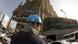 Ein asiatischer Arbeiter mit blauem Schutzhelm steht auf einer Baustelle in Doha, der Hauptstadt von Katar. - Foto: Arno Burgi (dpa) Ein asiatischer Arbeiter mit blauem Schutzhelm steht auf einer Baustelle in Doha, der Hauptstadt von Katar. - Foto: Arno Burgi (dpa)