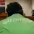 Человек в куртке, на которой написано "Гринпис", сидит в зале суда в Мурманске
