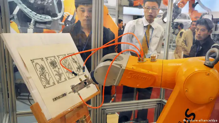 Visitors watch a robot arm of Staubli drawing during the 14th China International Industry Fair 2012 in Shanghai, China, 6 November 2012. A total of 1,648 companies from home and abroad participate in the 14th China International Industry Fair which is being held from November 6 to 10 at the Shanghai New International Expo Centre.