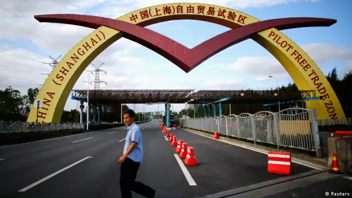 A man walks past a welcoming sign of the newly announced Shanghai Free Trade Zone in Shanghai in this September 25, 2013 file photo. China's leaders will lay out plans to transform the world's second-largest economy at a key party meeting in November, leaving the question of how to do it largely unanswered as much of the reform agenda is still a matter of heated internal debate. To match CHINA-ECONOMY/REFORMS REUTERS/Carlos Barria/Files (CHINA - Tags: POLITICS BUSINESS)