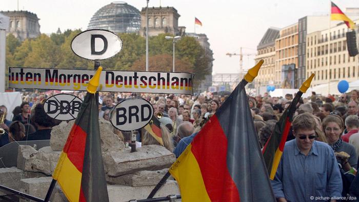 Passanten betrachten vor dem Reichstagsgebäude Mauerreste - Foto: dpa