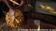 TO GO WITH India-religion-society-art,FEATURE by Rachel O'Brien This photo taken on September 3, 2012 shows an Indian carpenter placing original gold leaf paint on a statue at the Sequeira brothers' home and workshop in Small Giriz, some 70 kms north of Mumbai. For when a photograph is not enough, the Sequeiras -- a third-generation family of religious effigy makers -- operate a successful sideline to bereaved relatives who want a three-dimensional tribute to their lost loved ones. Using old photographs to capture a likeness, the statues and busts are made of wood or fibreglass, coloured with paint and completed with realistic glass eyes. AFP PHOTO / INDRANIL MUKHERJEE (Photo credit should read INDRANIL MUKHERJEE/AFP/Getty Images)