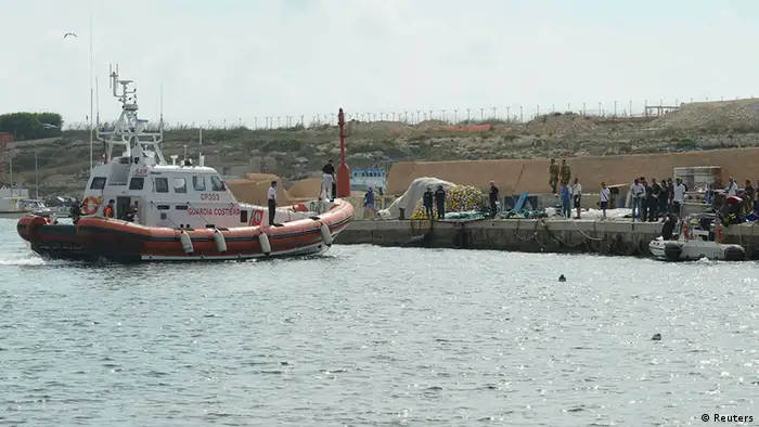 A coastguard vessel manoeuvres after unloading body bags containing African migrants, who drowned trying to reach Italian shores, in the harbour of Lampedusa October 3, 2013. At least 94 people died and scores were missing after a boat carrying migrants from Africa sank off the Sicilian island of Lampedusa on Thursday, officials and rescuers said. The coastguard said it appeared that there were between 400 and 500 migrants on the boat when it sank, and 150 had been saved so far. REUTERS/Enza Billeci (ITALY - Tags: SOCIETY IMMIGRATION DISASTER POLITICS)