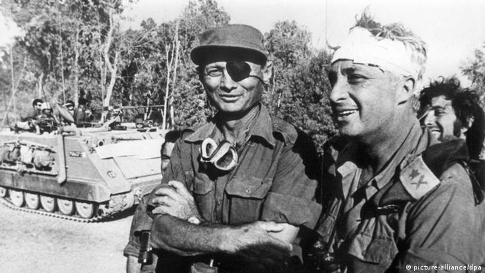 Der israelische Verteidigungsminister und General Mosche Dajan (l.) mit Generalmajor Ariel Scharon (r.), der einen Kopfverband trägt. - (c) dpa - Bildfunk
