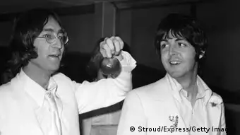 Beatles John Lennon and Paul McCartney at London Airport after a trip to America to promote their new company Apple Corps, 16th May 1968. They are both dressed all in white and carrying apples. (Photo by Stroud/Express/Getty Images)