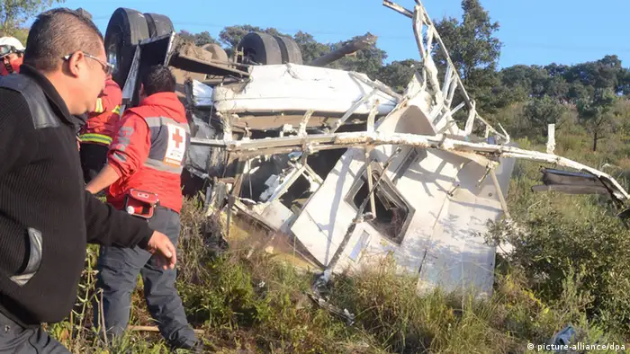 epa03896410 Rescue teams work at the site where a bus fell down a hill as it was travelling the road that links Naucalpan with Toluca, in Mexico, 04 October 2013. Twelve people died and another 20 were injured in the accident. EPA/STR