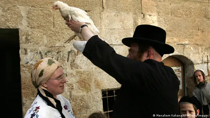 Während der Kaparot-Zeremonie am Vorabend des Jom-Kippur-Fests schwingt ein ultraorthodoxer Jude ein Huhn über den Kopf einer Frau. - AFP PHOTO/Menahem Kahana (MENAHEM KAHANA/AFP/Getty Images)