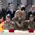 Bundesminister Westerwelle und de Maizière sowie die afghanischen Minister Daudzai und Nazari beobachten, wie Armeevertreter die Übergabedokumente austauschen - Foto: Fabrizio Bensch