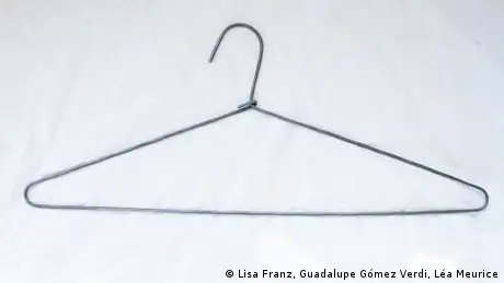 A wire clothes hanger on a white bedsheet. (Copyright: Lisa Franz, Guadalupe Gómez Verdi, Léa Meurice)