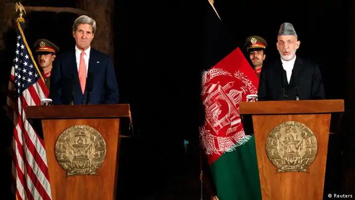 Afghanistan's President Hamid Karzai (R) speaks during a joint news conference with U.S. Secretary of State John Kerry in Kabul October 12, 2013. Kerry and Karzai said on Saturday major issues over a bilateral security agreement had been resolved but the question of immunity for U.S. troops would have to be decided by a assembly of elders and leaders. REUTERS/Mohammad Ismail (AFGHANISTAN - Tags: POLITICS)