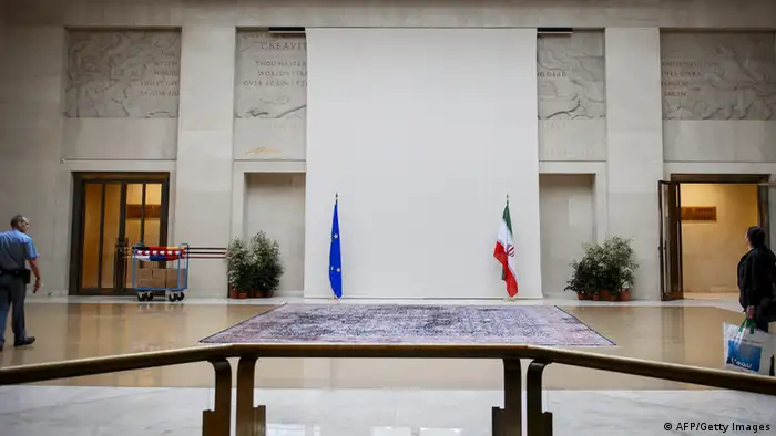 A security guard walks near a sculpture of a naked man covered up by a curtain behind the European and Iranian flags on October 14, 2013 at the United Nations' Geneva offices, ahead of fresh talks between world powers and Iran on its controversial nuclear programme. The cover-up of the marble man and his clearly visible penis was first reported by the Swiss newspaper Tribune de Geneve, which claimed that the aim was to avoid offending the Islamic republic's delegation talks. Swiss officials declined to address the newspaper's claim, and told AFP that the aim was to provide a neutral backdrop at the entrance to the meeting hall. AFP PHOTO / FABRICE COFFRINI (Photo credit should read FABRICE COFFRINI/AFP/Getty Images)