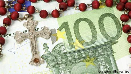 Ein Rosenkrank mit Kreuz liegt auf einem 100 Euro-Geldschein (picture-alliance/dpa)