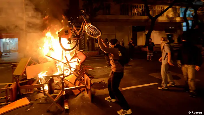 An anti-government protester throws a bike onto a fire during a clash with riot police after a protest supporting a teachers' strike in Rio de Janeiro October 15, 2013. The protest is to demand changes in the public state and municipal education system. REUTERS/Lucas Landau (BRAZIL - Tags: CIVIL UNREST POLITICS EDUCATION)