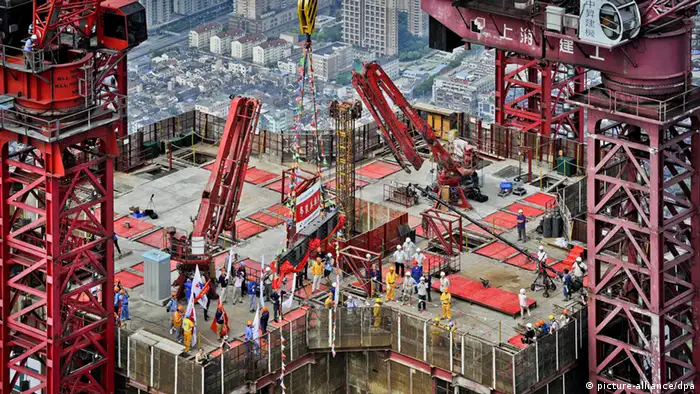 ARCHIV - Arbeiter bringen am 03.08.2013 in Shanghai den letzten Stahlträger des 632-Meter hohen Shanghai Towers in Position. Am Freitag (18.10.2013) werden in Peking Zahlen vorgestellt, die Chinas Wirtschaftswachstum im dritten Quartal beziffern sollen. Foto: An Tu/epa/dpa (zu dpa-meldung vom 18.10.2013) +++(c) dpa - Bildfunk+++