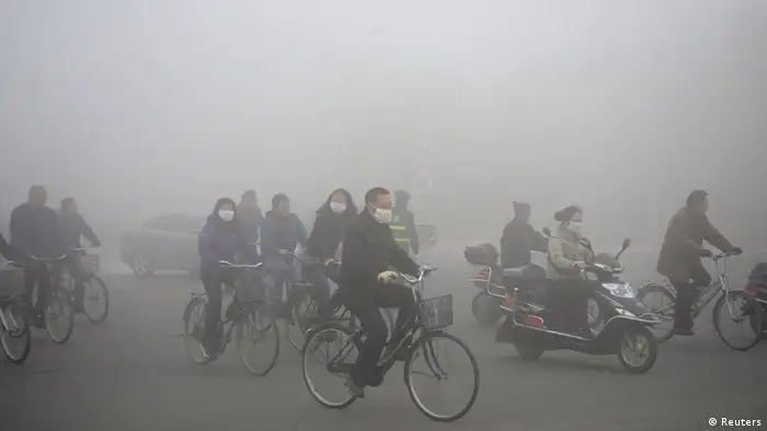 People ride along a street on a smoggy day in Daqing, Heilongjiang province, October 21, 2013. The highest red alert was issued for heavy smog in several cities in Heilongjiang province on Monday, according to Xinhua News Agency. The second day of heavy smog with a PM 2.5 index has forced the closure of schools and highways, exceeding 500 micrograms per cubic meter on Monday morning in downtown Harbin, the provincial capital. REUTERS/Stringer (CHINA - Tags: ENVIRONMENT SOCIETY) CHINA OUT. NO COMMERCIAL OR EDITORIAL SALES IN CHINA