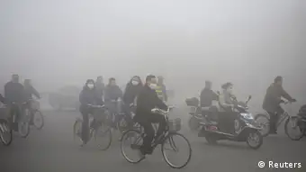 People ride along a street on a smoggy day in Daqing, Heilongjiang province, October 21, 2013. The highest red alert was issued for heavy smog in several cities in Heilongjiang province on Monday, according to Xinhua News Agency. The second day of heavy smog with a PM 2.5 index has forced the closure of schools and highways, exceeding 500 micrograms per cubic meter on Monday morning in downtown Harbin, the provincial capital. REUTERS/Stringer (CHINA - Tags: ENVIRONMENT SOCIETY) CHINA OUT. NO COMMERCIAL OR EDITORIAL SALES IN CHINA