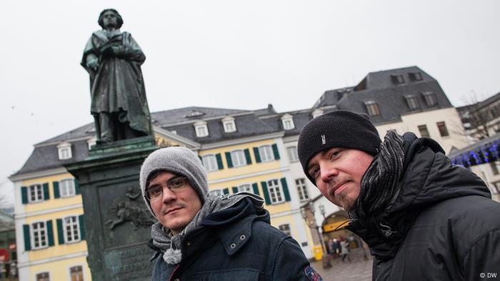 Bandmitglieder Tobias und Kurt vor einem Denkmal des Komponisten Ludwig van Beethoven in der Bonner Innenstadt