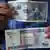 A man shows two bills of 20 pesos, one of Peso Cubano 'CUP' (Top) and other of Peso Convertible Cubano 'CUC' (bottom) in Havana, Cuba, 22 October 2013. EPA/ALEJANDRO ERNESTO +++(c) dpa - Bildfunk+++