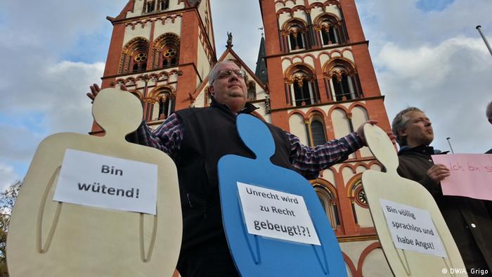 Theologe und Religionslehrer Frank Speth mit Protestschildern gegen die Aktuelle Bistumsleitung vor dem Limburger Dom - Foto: Andreas Grigo (DW)