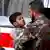 A handout picture made available by Syrian news agency (SANA) shows a Syrian soldier carrying a wounded child to receivE first aid at Al Muwasat Hospital in Damascus, after injured at the site of a car bomb attack near Osama bin Zaid Mosque in Souk Wadi Barada in Rural Damascus, Syria, 25 October 2013. dpa/EPA/SANA HANDOUT /eingest. sc