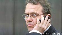 Bundesinnenminister Hans-Peter Friedrich (CSU) telefoniert am 11.12.2012 nach der Fraktionssitzung im Reichstagsgebäude in Berlin mit seinem Handy. Zuvor hatte er sich gegenüber von Journalisten zu der Festnahme im Fall eines möglicherweise geplanten Bombenanschlags in Bonn geäußert. Foto: Wolfgang Kumm/dpa