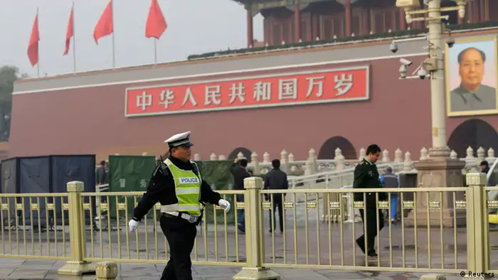 A policeman walks past in front of the giant portrait of the late Chinese Chairman Mao Zedong as other policemen clean up after a car accident at the Tiananmen Square in Beijing, October 28, 2013. Chinese police on Monday evacuated Beijing's Tiananmen Square, the site of 1989 pro-democracy protests bloodily suppressed by the government, following a fire after a car ran into a crowd, a Reuters witness and state media said. REUTERS/Jason Lee (CHINA - Tags: SOCIETY POLITICS)