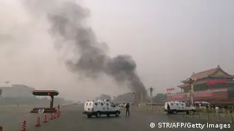 Police cars block off the roads leading into Tiananmen Square as smoke rises into the air after a vehicle crashed in front of Tiananmen Gate in Beijing on October 28, 2013. Three people were killed when an SUV vehicle crashed into a crowd in Beijing's Tiananmen Square and burst into flames, state media said, as pictures showed a tower of smoke rising before the Forbidden City. TOPSHOTS CHINA OUT AFP PHOTO (Photo credit should read STR/AFP/Getty Images)