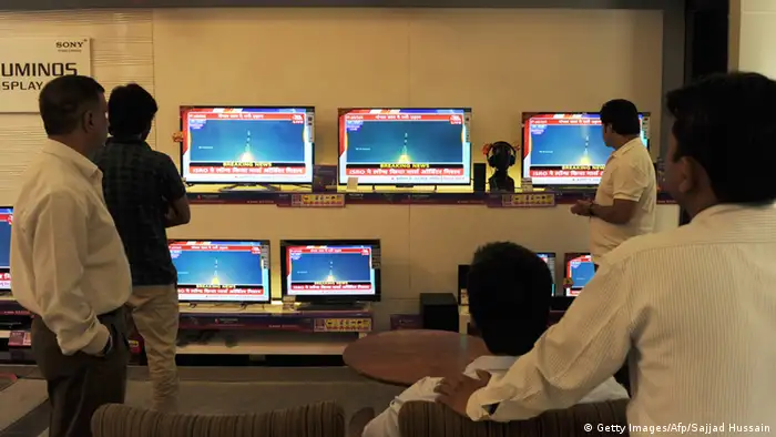 Indian bystanders watch a bank of screens showing the live telecast of the launch of India's Mars Orbiter Mission inside a showroom in New Delhi on November 5, 2013. (Photo: SAJJAD HUSSAIN/AFP/Getty Images) 