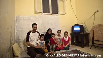 Syrian refugee Yussef al-Talha 29, who works as a computer technician from Deraa in southern Syria, sits with his family, (From L to R) son Mohamed, 5, wife Rem al-Sawaa, 28, son Khaled, 1, daughter Asma,12, and daughter Shayma, 8, at their home in the Helwaan district of the Egyptian capital of Cairo on November 1, 2013. AFP PHOTO / KHALED DESOUKI (Photo credit should read KHALED DESOUKI/AFP/Getty Images) Erstellt am: 01 Nov 2013