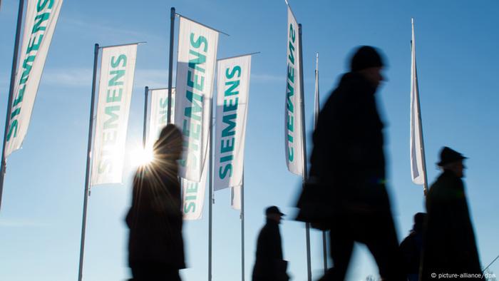 Siemens employees with flags (picture-alliance/dpa)