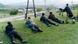 Armed men lie on the ground as a colleague opens fire. Armed men lie on the ground as a colleague opens fire.