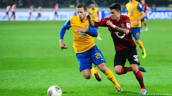 Braunschweig and Hanover players battle for the ball