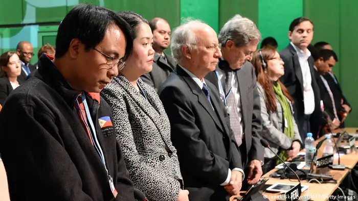 Representative of Philippines, Naderev Sano (L) and others delegates pay standing tribute to victims of deadly Philippines typhoon during the United Nations Climate Change Conference COP 19 on November 11, 2013 in Warsaw. Nations launched a new round of talks Monday for a 2015 deal to cut Earth-warming greenhouse gas emissions in the aftermath of a deadly Philippines typhoon the UN's climate chief labelled sobering. AFP PHOTO/JANEK SKARZYNSKI (Photo credit should read JANEK SKARZYNSKI/AFP/Getty Images)
