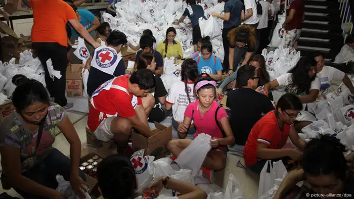 epa03946220 A handout picture made available by the Philippine Red Cross (PRC), shows volunteers helping in packing relief goods for typhoon-affected families in Manila, Philippines, 12 November 2013. International aid poured in for the Philippines as authorities stepped up efforts to reach survivors driven to looting after one of the world's strongest typhoons devastated their towns. A tropical depression brought heavy rains over the central and eastern Philippines, where provinces badly hit by Haiyan are located, raising concerns that relief operations would be hampered. EPA/PHILIPPINE RED CROSS HANDOUT EDITORIAL USE ONLY/NO SALES