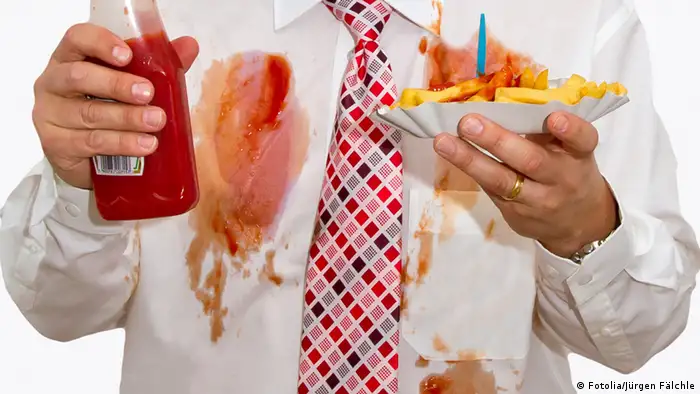Mann mit Ketchup Flecken am Hemd und Pommes in der Hand (Fotolia/Jürgen Fälchle)